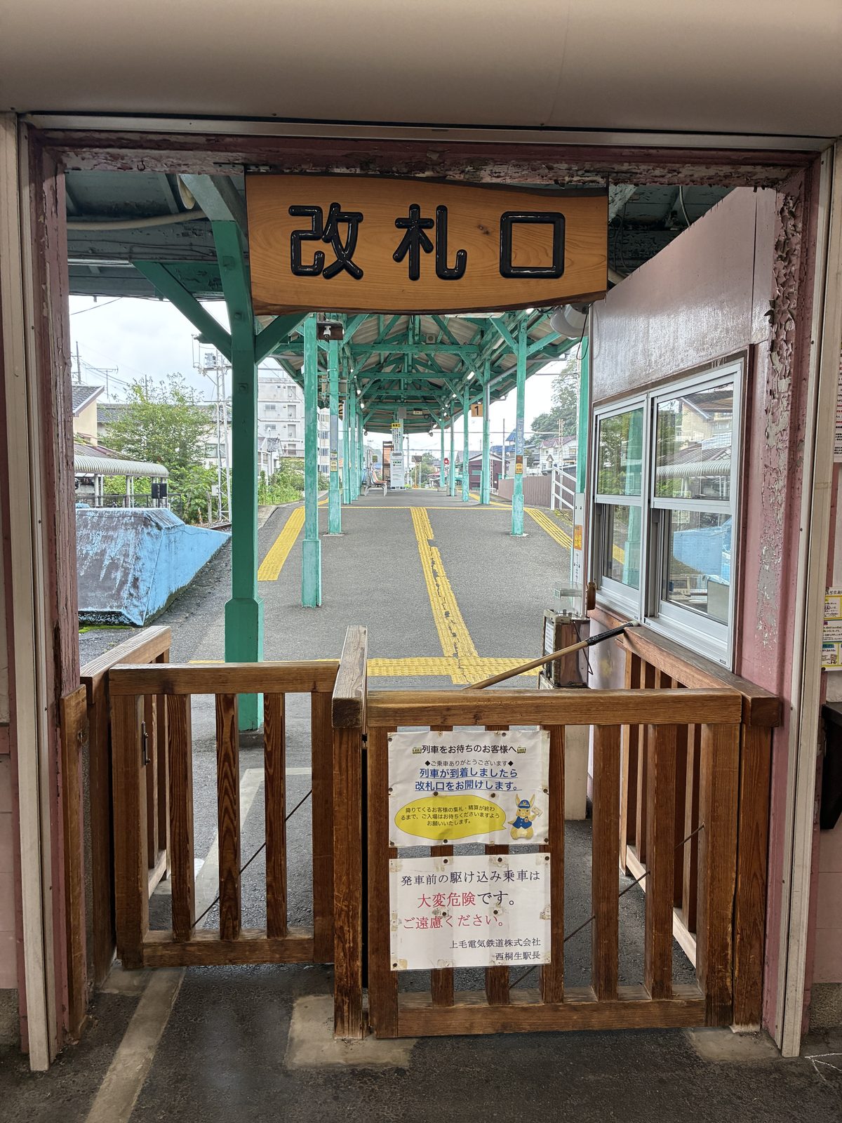 西桐生駅の木製の改札口。奥にホームの緑色の柱が見える