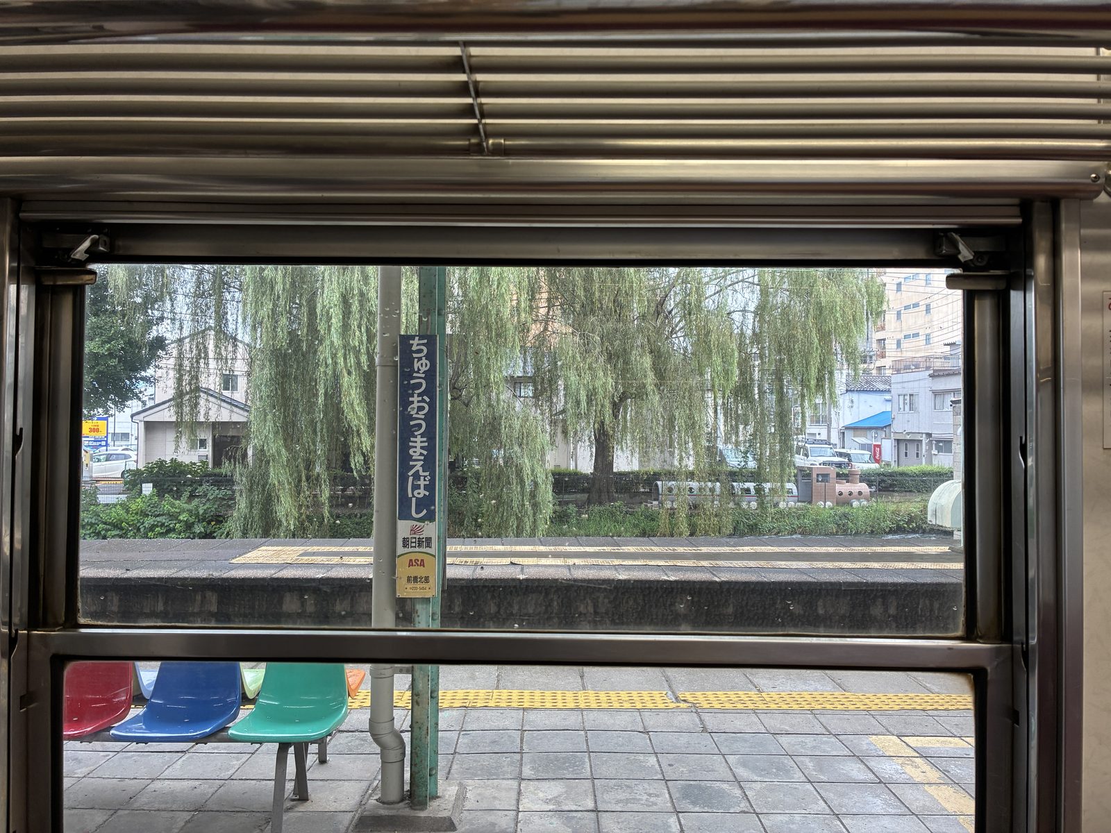 中央前橋駅。車内の窓から見た駅名標と、広瀬川沿いの柳